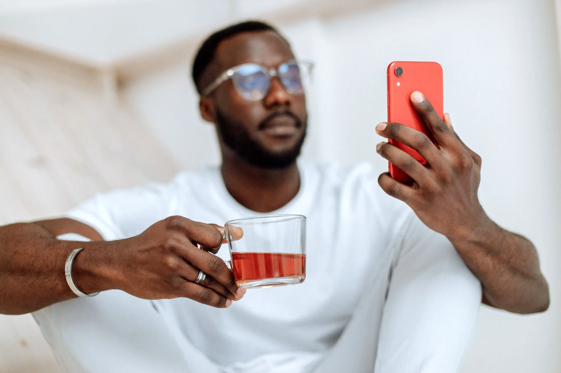 A man taking a quiet moment with his phone and a warm drink